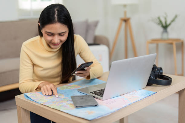 خانم جوانی در حال برنامهریزی سفر به تبریز با نقشه و لپتاپ، نشاندهنده اهمیت بازاریابی محتوایی سفر - استراتژی دیجیتال مارکتینگ و سئو جستجوی صوتی