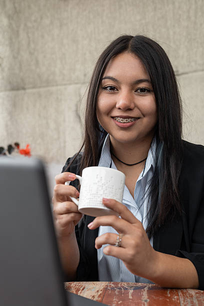 زن جوان در حال لبخند زدن با قهوه در محل کارش - استراتژی محتوایی رستوران، سئو محتوای رستوران، داستان سرایی برند رستوران
