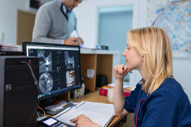 دندانپزشک در حال بررسی عکس رادیولوژی روی کامپیوتر در کلینیک دندانپزشکی، CRM پزشکی