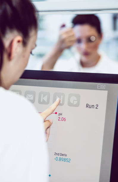 دانشمندی در حال کار با مانیتور کامپیوتر در آزمایشگاه، پیادهسازی راهکارهای دیجیتال آزمایشگاهی و بهینهسازی آزمایشگاه