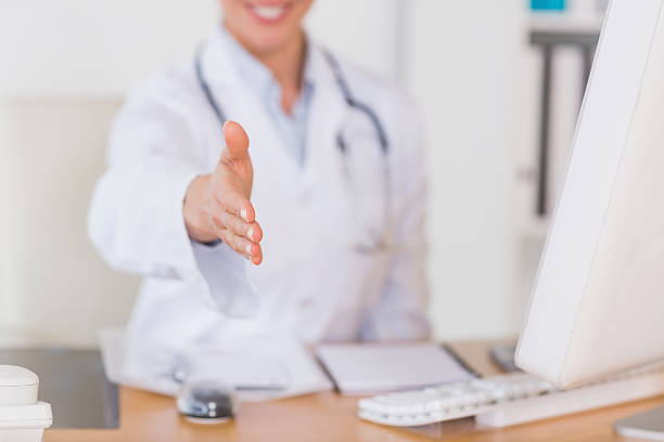 CRM پزشکی و سئو سایت پزشکان فوق تخصص گوارش و کبد در شیراز: پزشک در حال ارائه دست دادن، نشانگر اعتماد و ارتباط با بیمار در بازاریابی دیجیتال سلامت