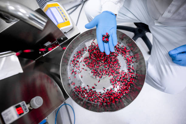 نمای نزدیک از دستهای یک مرد در آزمایشگاه در حال نگهداشتن قرصها. تولید مواد اولیه دارویی و کنترل کیفیت در تهران در ۲۰۲۶