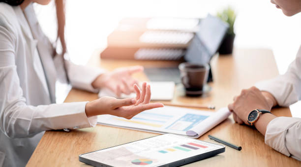 نمایی از دستهای افراد در حال کار با نمودار و چارت: مشاوره دیجیتال مارکتینگ سلامت، افزایش جذب مراجعین پزشکی