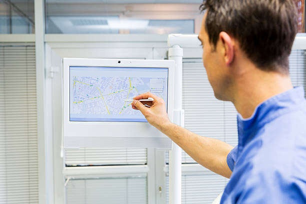 طراحی پرتال نوبتدهی آنلاین هوشمند برای کلینیکهای جراحی محدود در مشهد - دندانپزشک در حال نشان دادن موقعیت مطب خود روی صفحه دیجیتال 2026