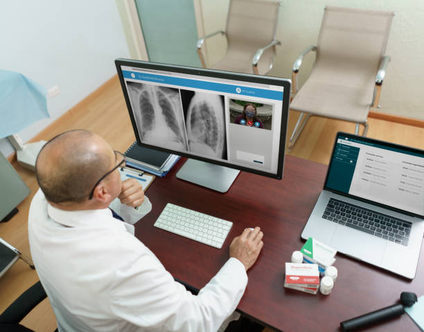 نوبت دهی آنلاین پزشکی و تلهمدیسین - پزشک در حال بررسی پرونده بیمار در یک جلسه مشاوره آنلاین، نمایش کاربرد فناوری در پزشکی