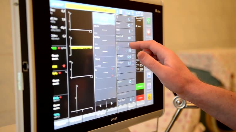 دکتر در حال کار با مانیتور تجهیزات پزشکی، طراحی سایت پزشکی و مدیریت سیستم پذیرش بیمار