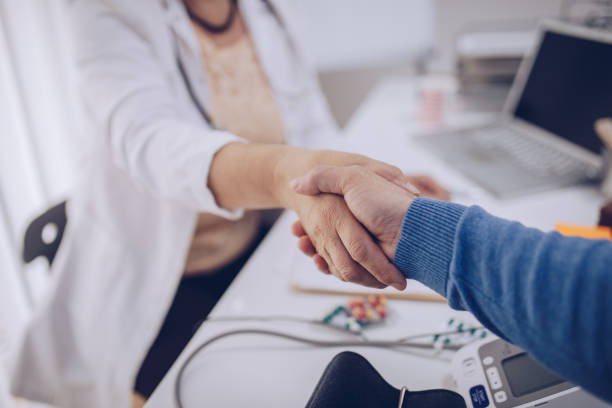 پزشک در دفتر کار خود با بیمار دست میدهد - ارتقاء اعتماد بیماران و پشتیبانی وبسایت سلامت