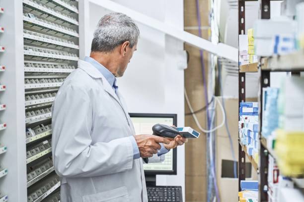 داروخانههای تخصصی در کرمان: توسعه وب و CRM پزشکی برای بهینهسازی مدیریت موجودی و نوبتدهی دارو 2026 - داروساز در حال اسکن دارو در انبار