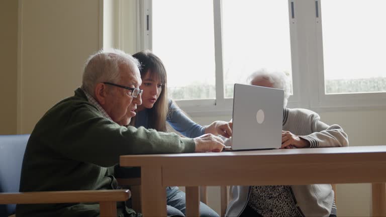 پشتیبانی وبسایتهای درمانی و امنیت سایبری برای مراکز سالمندان در تهران: پایداری با وردپرس پزشکی 2026 - خانواده در حال کمک به سالمند برای استفاده از لپتاپ