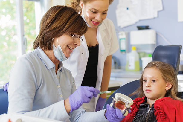 دندانپزشک زن با بیمار کودک، نمادی از اهمیت طراحی UX کودکمحور و جلب اعتماد والدین دندانپزشکی