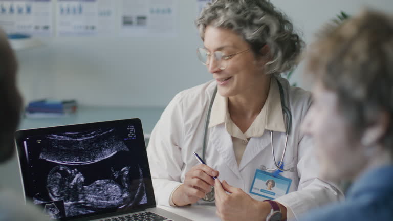 برندینگ دیجیتال پزشکی و سئو پزشکی - پزشک زن در حال بحث سونوگرافی جنین روی لپ تاپ با یک زوج