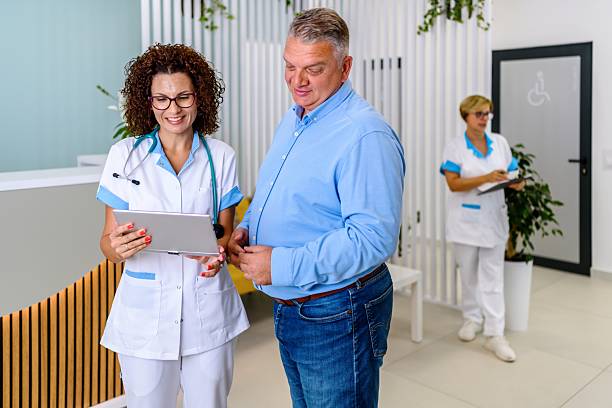 توسعه وب و CRM پزشکی برای مراکز مراقبت طولانیمدت در تبریز: پزشک زن در حال صحبت با بیمار سالخورده در لابی بیمارستان، نمایانگر اهمیت ارتباط انسانی و بهبود ارتباطات با CRM مراکز درمانی