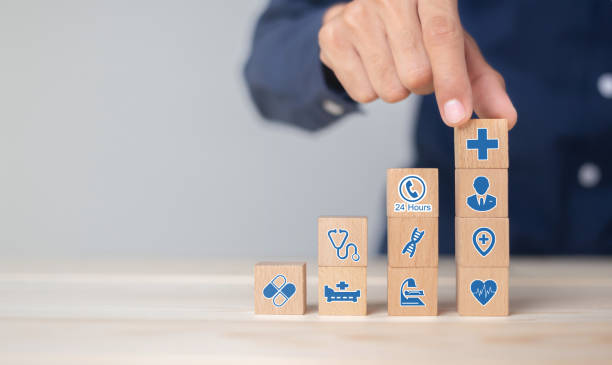 نرمافزارهای مدیریت بیمارستان و CRM پزشکی برای بیمارستان عمومی در تبریز: توسعه وب و ارتقاء خدمات 2026 - چیدمان بلوکهای چوبی با نمادهای مراقبتهای بهداشتی و بیمه سلامت