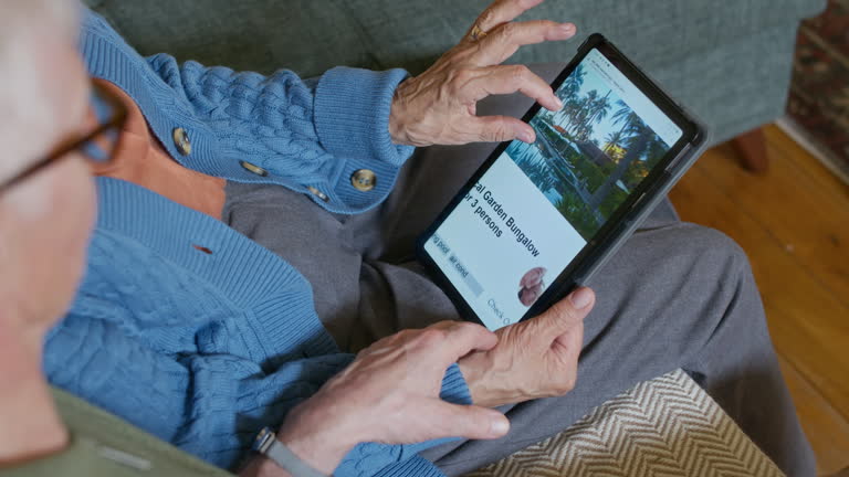 طراحی UX بیماران برای مراکز سالمندان در قزوین - زن سالمندی در حال استفاده از تبلت برای مشاهده وبسایت درمانی و بهبود تجربه بیماران