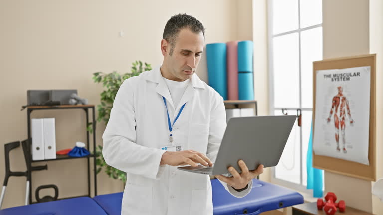 طراحی UX بیماران و پشتیبانی سایت کلینیک برای مراکز فیزیوتراپی در سنندج: پزشک در کلینیک فیزیوتراپی مدرن در حال کار با لپتاپ