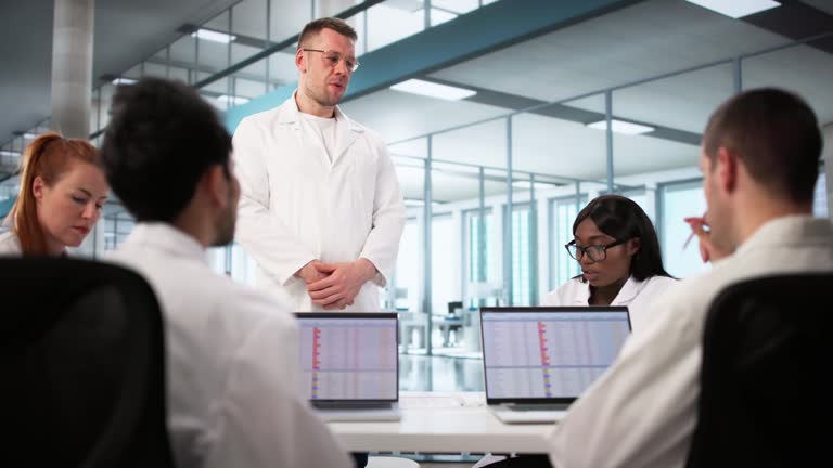 تیم پزشکی در حال استفاده از لپ تاپ برای مدیریت آزمایشگاه پزشکی و نوبت دهی آنلاین آزمایشگاه