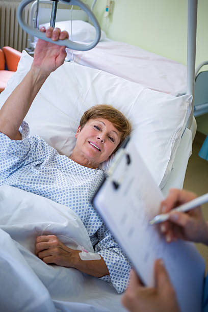 بیمار در حال استراحت و پرستار در حال ثبت اطلاعات در سیستم CRM پزشکی