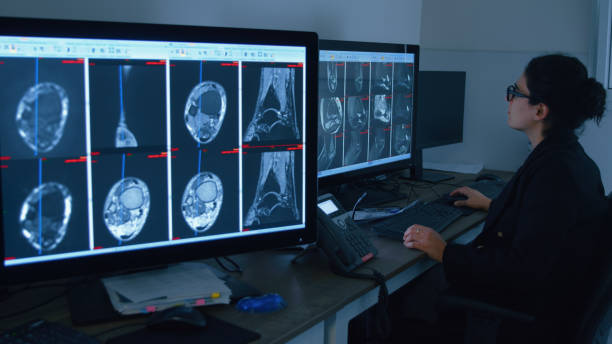 طراحی UX بیمارمحور برای مراکز MRI و CT Scan در کرمان: رادیولوژیست در حال بررسی تصاویر پزشکی با رویکرد بهبود تجربه بیمار