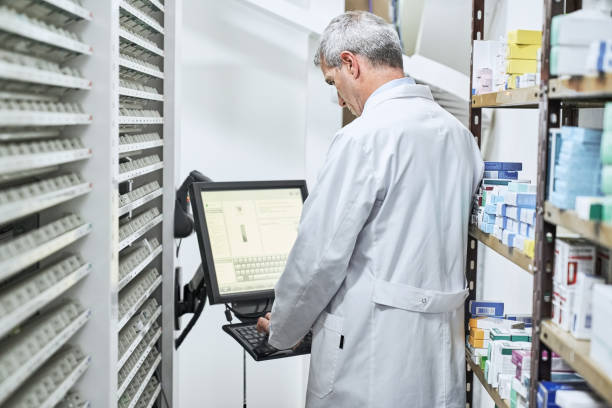 داروساز در حال کار با سیستمهای اطلاعاتی داروخانه و مدیریت موجودی با کمک توسعه وب داروخانه برای داروخانههای زنجیرهای در کرمان