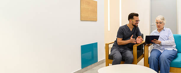 طراحی UX بیماران و CRM پزشکی برای مراکز فیزیوتراپی در تبریز - یک زن سالخورده در حال بحث در مورد پرونده پزشکی و وضعیت سلامت با پزشک متخصص، که اهمیت پرونده الکترونیکی و ارتباطات مؤثر را نشان میدهد.