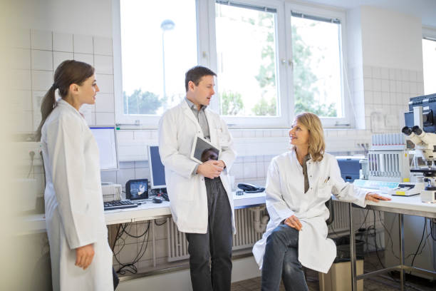 تصویری از همکاران پزشکی در حال گفتگو در آزمایشگاه، نشاندهنده همکاری برای ارتقاء خدمات سلامت و سئو آزمایشگاه تشخیص طبی 2026