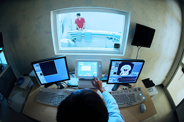 پزشک در حال بررسی تصاویر MRI با کامپیوتر، نمادی از ادغام فناوری و پزشکی در مراکز تصویربرداری اهواز.
