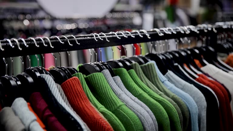 قفسه لباسهای بافتنی رنگارنگ در فروشگاه – مد و پوشاک عمده، فروشیاب، خرید و فروش عمده، آگهی تجاری