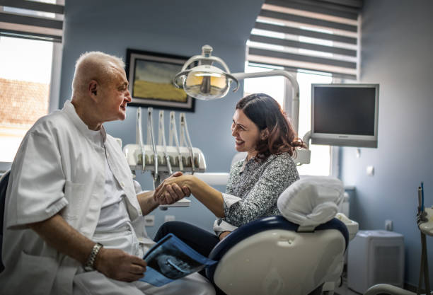 جذب مراجعین جدید دندانپزشکی در اصفهان، دندانپزشک در مطب با بیمار صحبت میکند