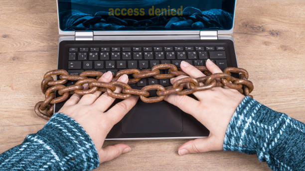خدمات پشتیبانی سایت و امنیت سایبری برای مراکز درمانی - دستها روی لپتاپ و زنجیر