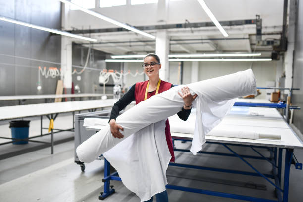 کارگر نساجی در حال حمل رول پارچه | فروش‌یاب، خرید و فروش عمده، آگهی تجاری