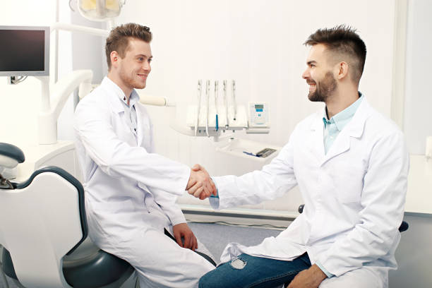 سئو سایت دندانپزشکی زیبایی اصفهان - دو دکتر دندانپزشک در حال دست دادن - پینوسایت