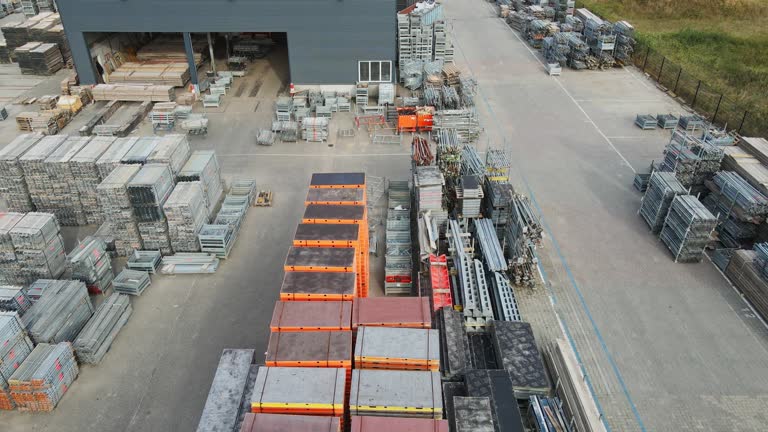 نمای هوایی از حیاط انبار صنعتی با مصالح ساختمانی مرتب و سازمانیافته، بیانگر فرصتهای خرید و فروش عمده در فروشیاب