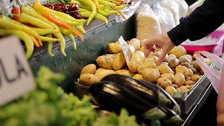 خرید و فروش عمده محصولات کشاورزی: مردی در حال جمعآوری سیبزمینی در بازار عمده فروشان