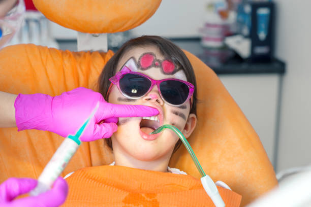 سئو سایت پزشکان دندانپزشکی کودکان در تبریز: ارتقای برندینگ دیجیتال - دختربچه بامزه در صندلی دندانپزشکی با عینک آفتابی