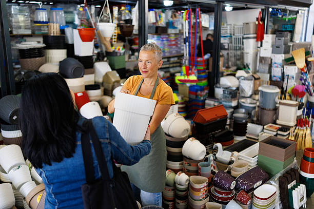 زن در حال خرید عمده گلدان در فروشگاه | فروش‌یاب، خرید عمده، آگهی تجاری