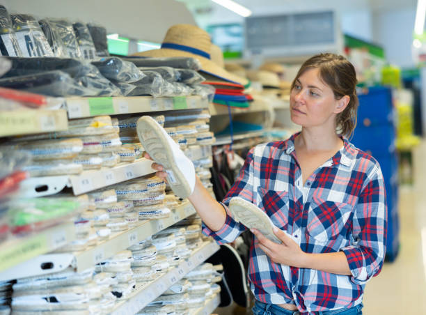 فروش‌یاب: سامانه تخصصی خرید و فروش عمده، تصویر زن جوانی که در سوپرمارکت به دنبال کفش تابستانی راحت می‌گردد برای جستجوی محصولات عمده