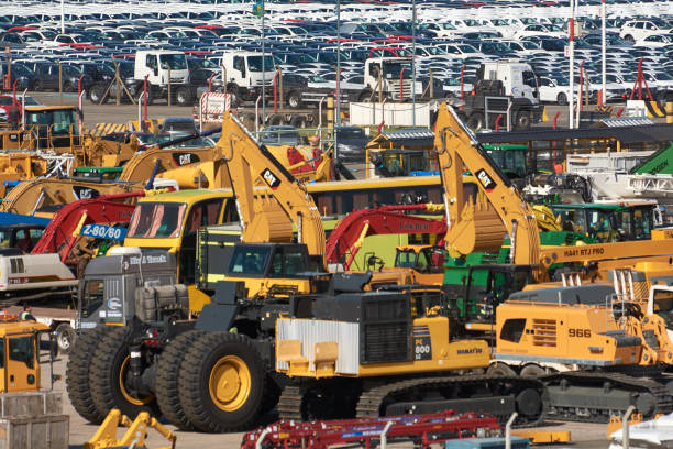 خرید و فروش عمده ماشینآلات صنعتی: خودروها و کامیونهای متعدد در حال بارگیری برای انتقال به کشورهای مختلف، نشاندهنده گستردگی بازار در فروشیاب